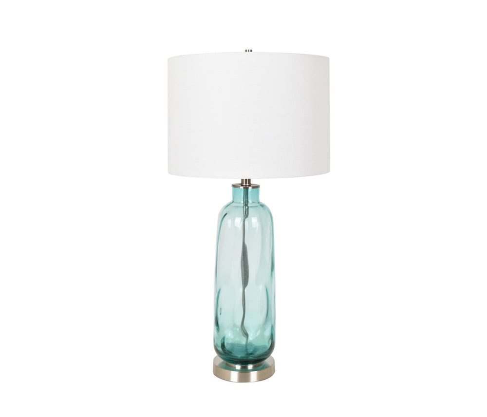 A tall glass table lamp with a white shade, featuring a blue tint at the base and a metallic rim.