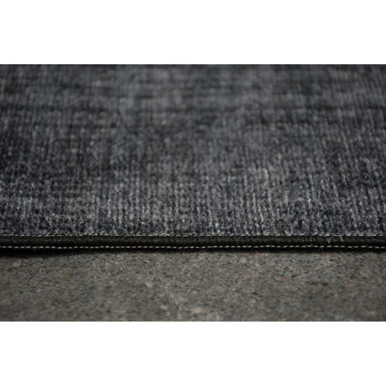 A dark navy area rug with a textured weave pattern, designed for use in a bedroom or hallway.
