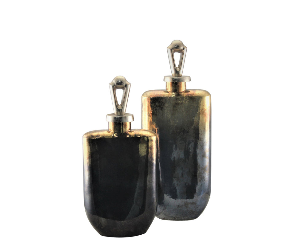 Two art glass bottles with brushed brass plated lids, one larger and one smaller, with an iridescent blue-gray hue.