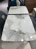Dining table with marble-like top and gold legs