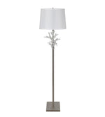Floor lamp with decorative base and white shade on a white background