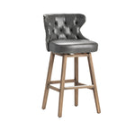 Gray cushioned bar stool with wooden legs on a white background