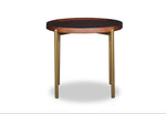 Round wooden table with black top and brass legs on a white background