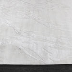 A power loomed Mila Area Rug in off white with a polypropylene and polyester construction and jute backing.