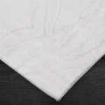 A power loomed Mila Area Rug in off white with a polypropylene and polyester construction and jute backing.