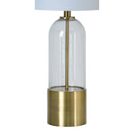 A mid-century modern table lamp with antique brass plated iron base and clear glass element, topped with an off-white shade.