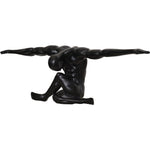 A black matte statue of a figure with arms outstretched, standing on a base, with a matte finish.
