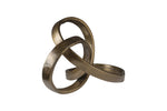 A sculpted ribbon-shaped decorative object with a brass finish.