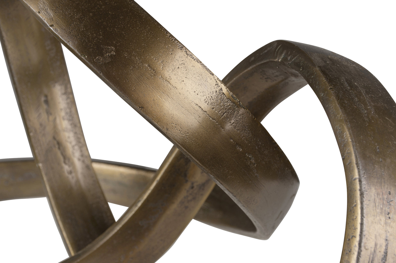 Close-up a sculpted ribbon-shaped decorative object with a brass finish.