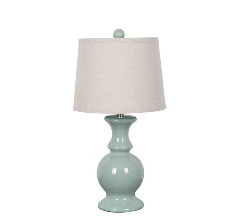 A dusty blue ceramic table lamp with a cream linen fabric shade.